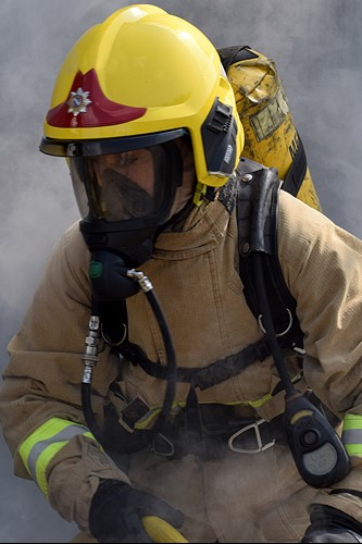 Photograph of firefighter wearing breathing apparatus surrounded my smoke.
