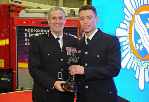 Chief Fire Officer Phil Garrigan presents the 'Top Recruit' award to Leon Lewis